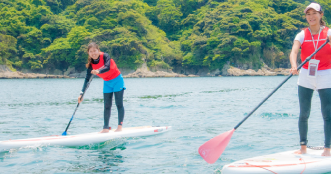 江ノ島とSUPをしている人々